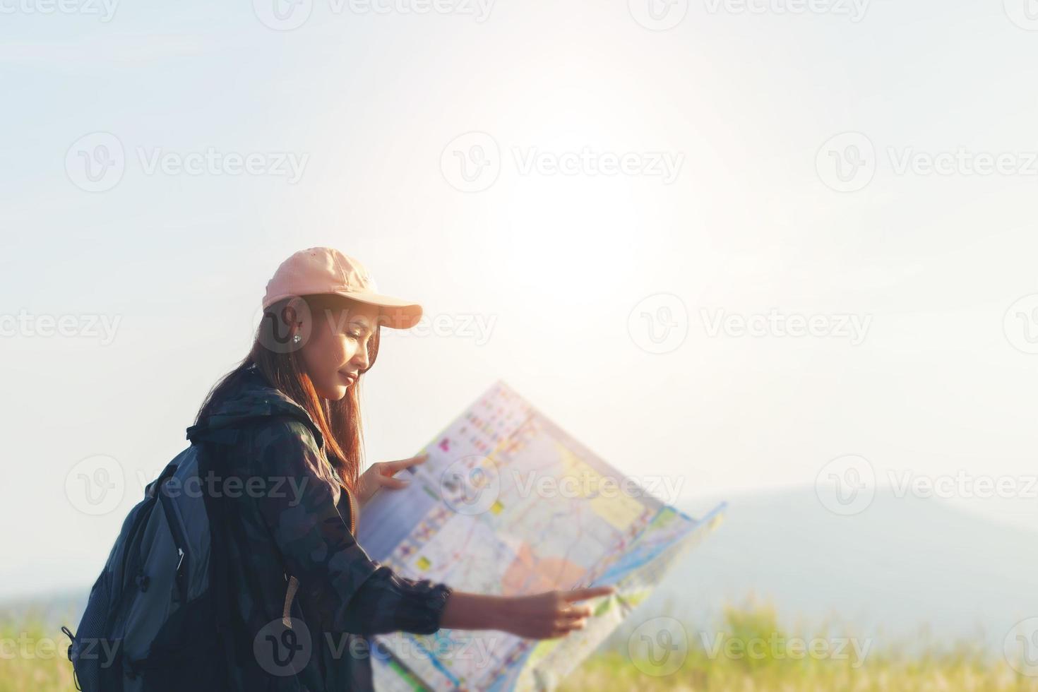 jeunes femmes asiatiques faisant de la randonnée avec des amis sacs à dos marchant ensemble et regardant la carte et prenant un appareil photo au bord de la route et ayant l'air heureux, détendez-vous pendant les vacances concept de voyage