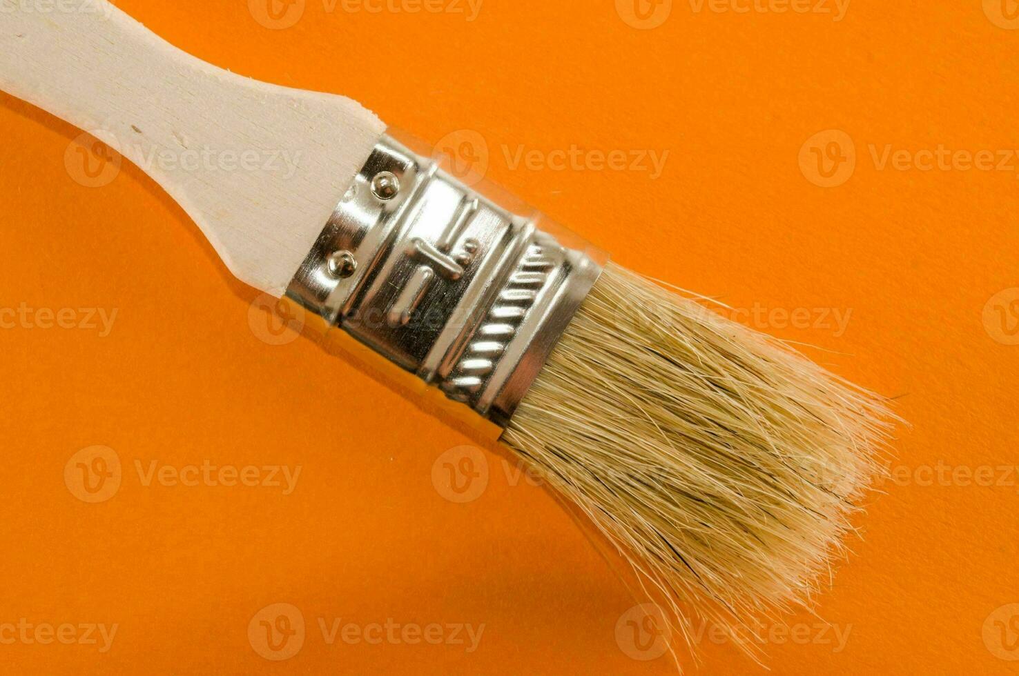 une brosse avec une blanc manipuler sur un Orange Contexte photo