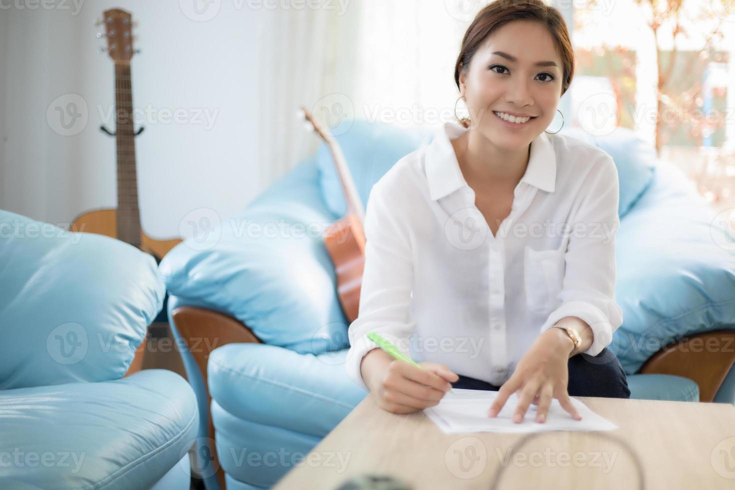 belles femmes d'affaires asiatiques écrivant un document de vérification des données et souriantes heureuses de travailler photo