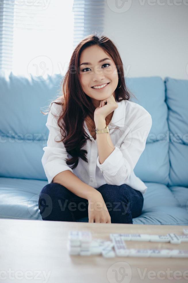 femmes asiatiques souriantes heureuses de se détendre sur un canapé à la maison photo