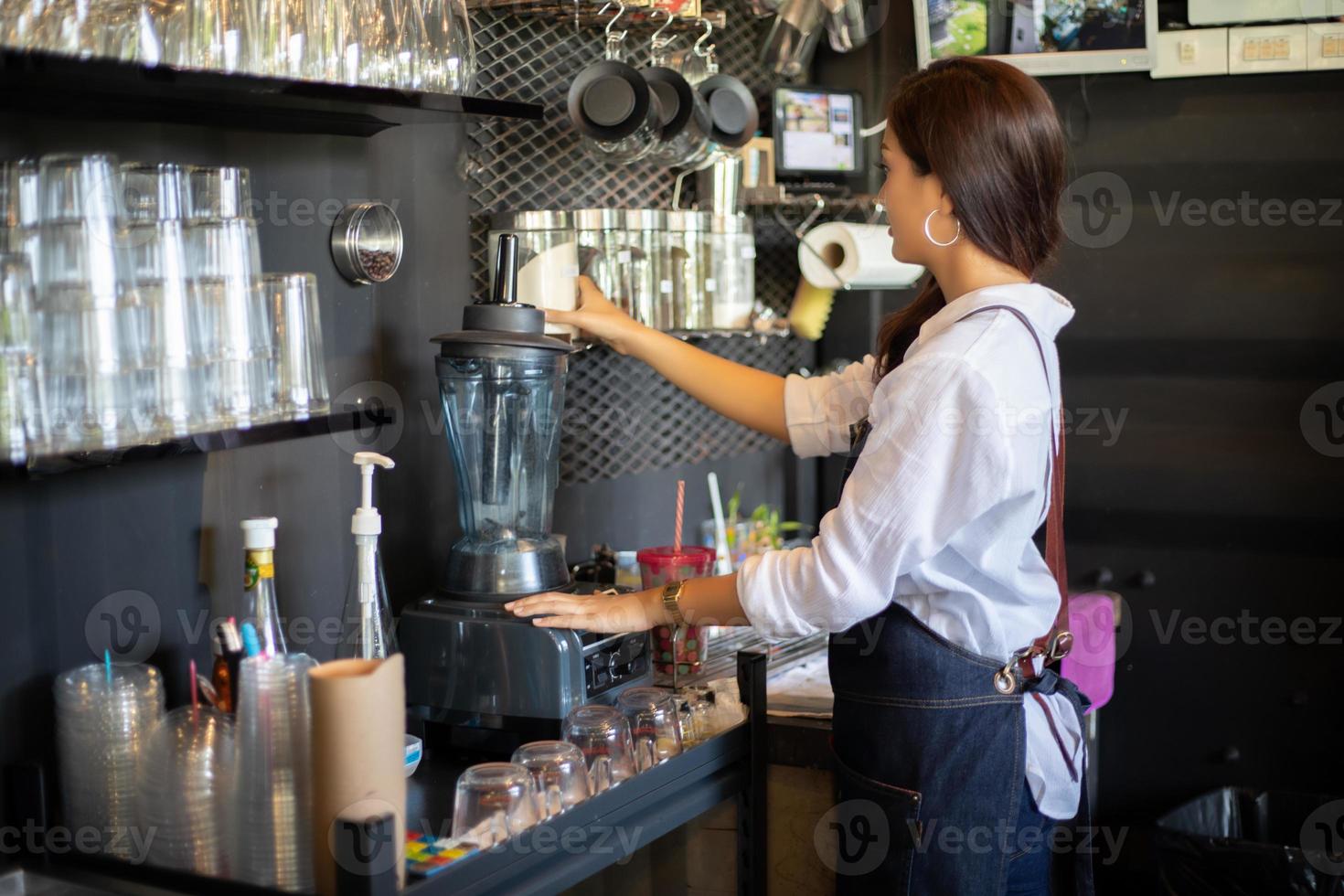 femmes asiatiques barista souriant et utilisant une machine à café dans un comptoir de café - femme qui travaille propriétaire de petite entreprise concept de café de nourriture et de boisson photo