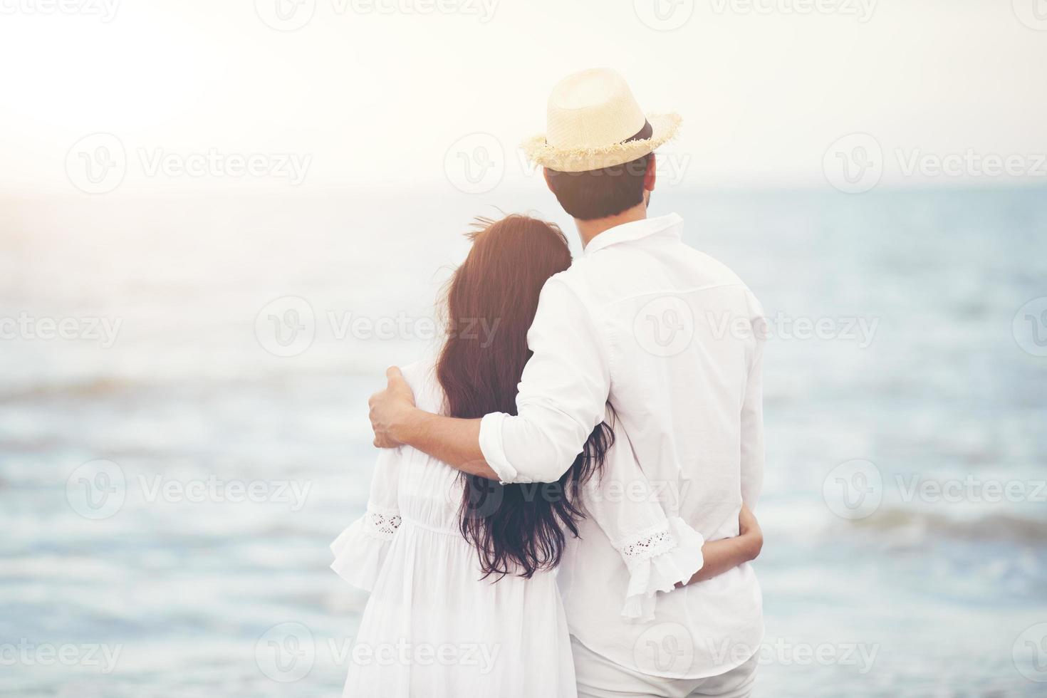 amoureux des couples romantiques heureux se tenant la main ensemble marchant sur la plage photo