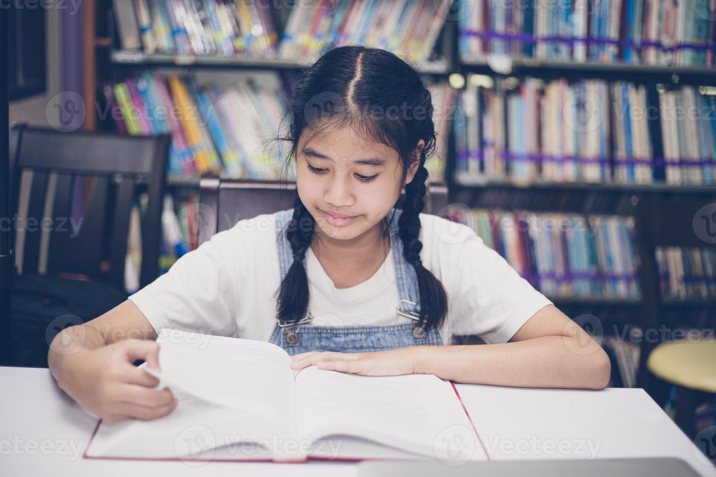 étudiants asiatiques lisant des livres dans la bibliothèque. photo