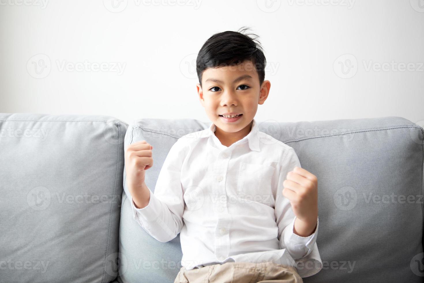 famille et fils excités et heureux avec les bras levés en regardant la télévision à la maison photo