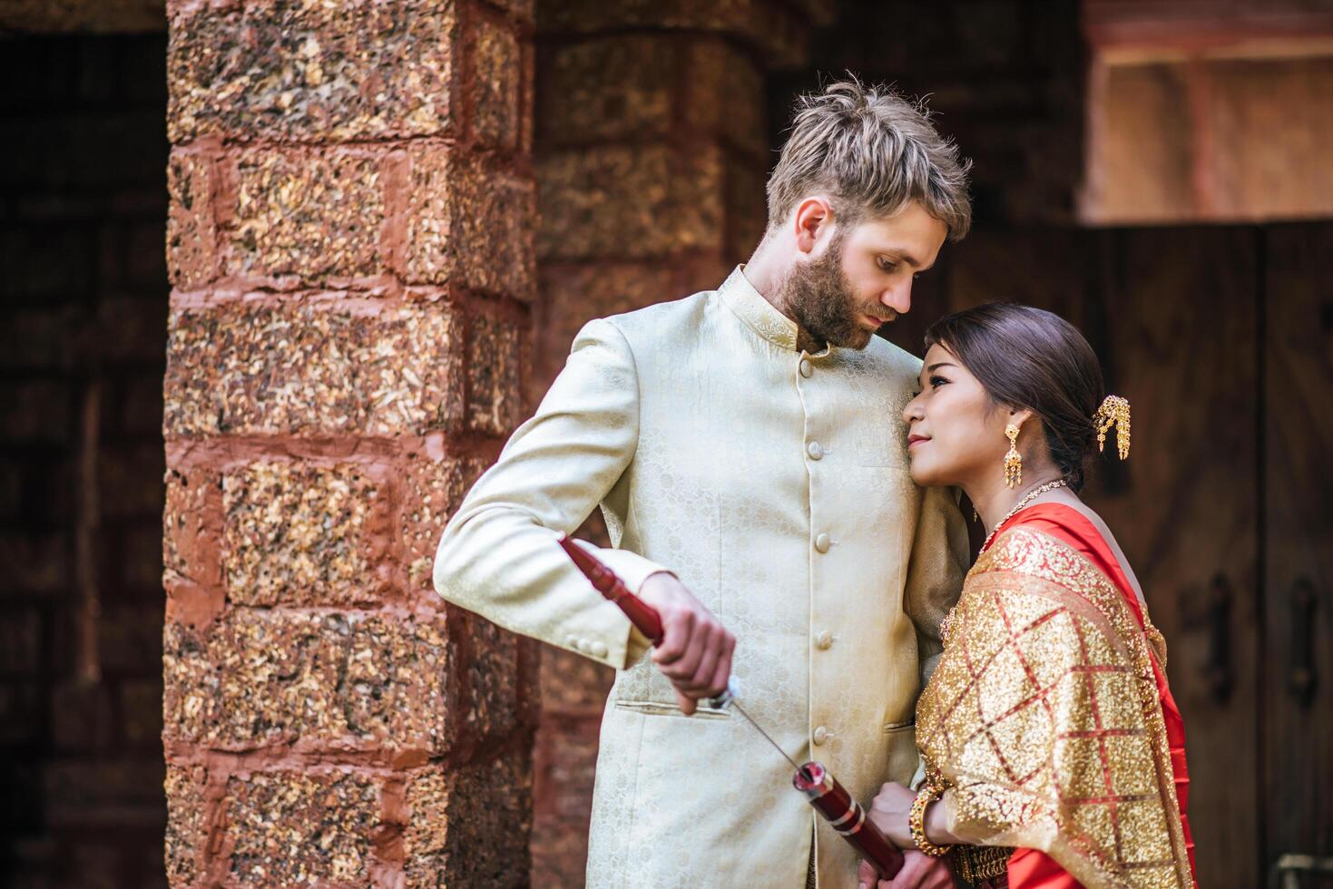 la mariée asiatique et le marié caucasien passent un moment romantique avec une robe thaïlandaise photo