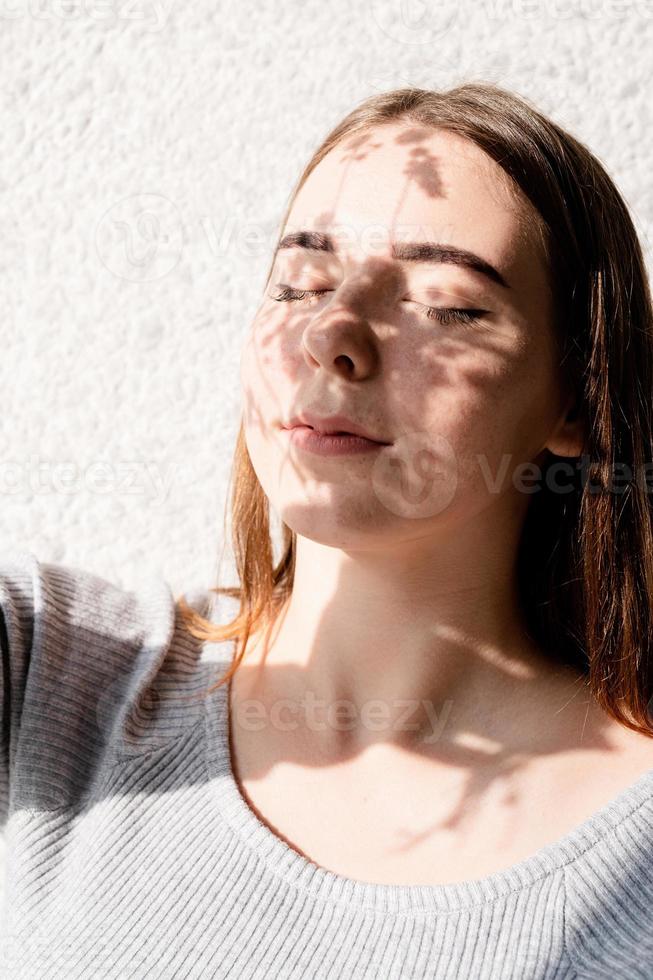 portrait d'une belle jeune femme avec un motif d'ombre sur le visage et le corps sous forme de fleurs photo