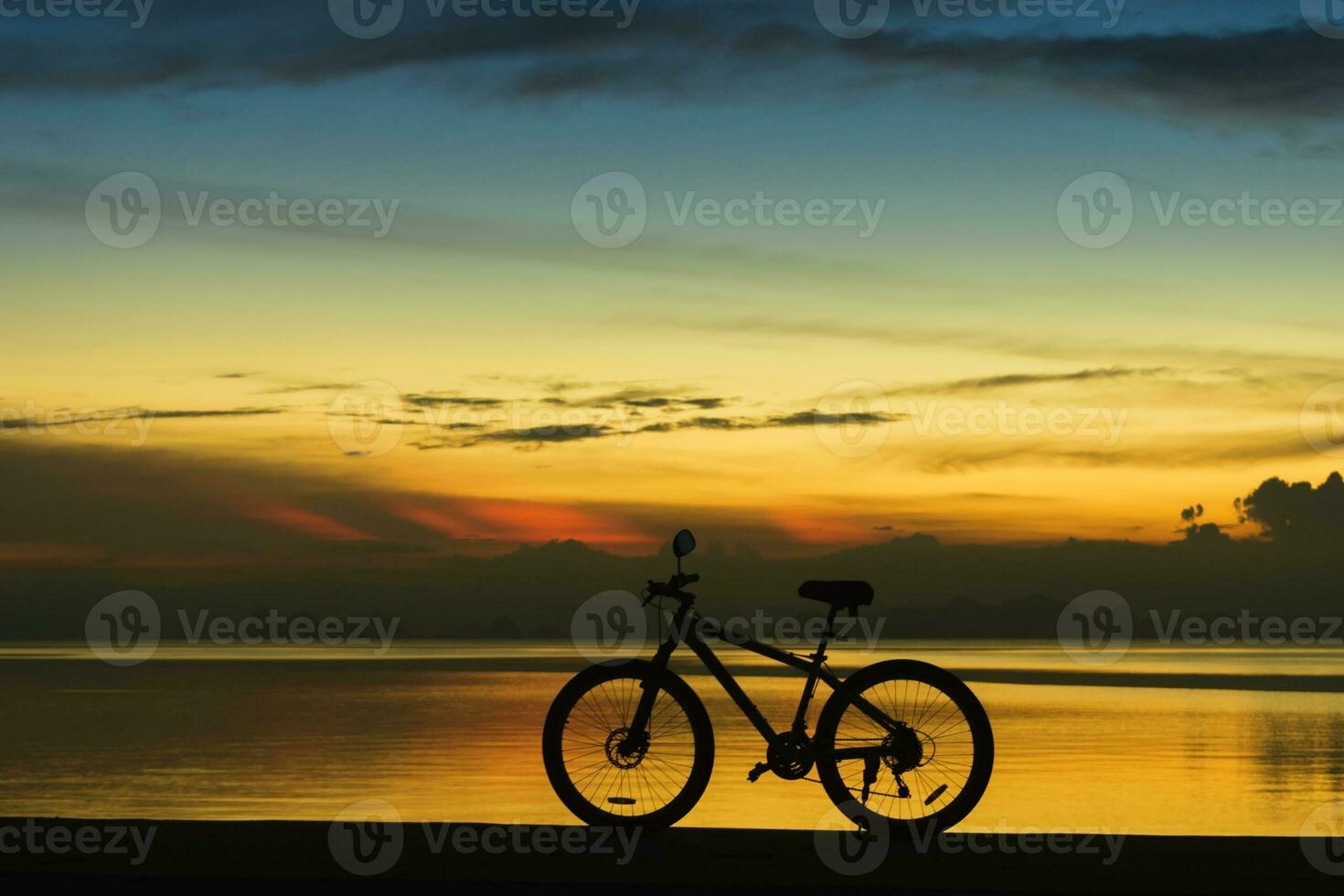 silhouette de une bicyclette sur une Lac à crépuscule. photo