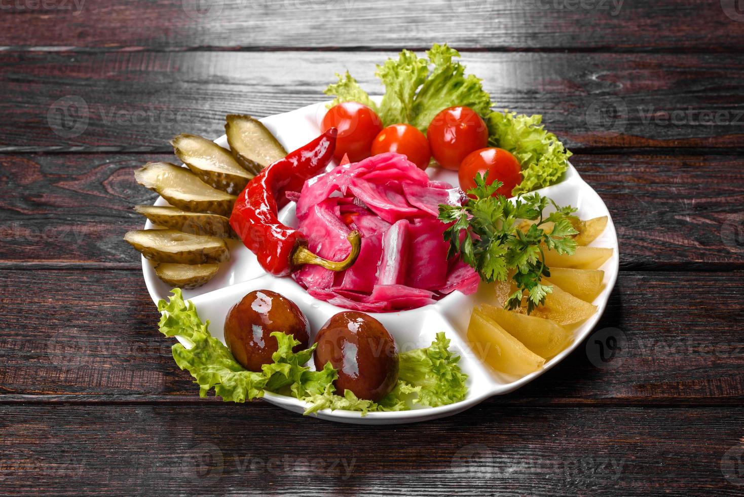 délicieux cornichons épicés coupés sur une assiette de service photo