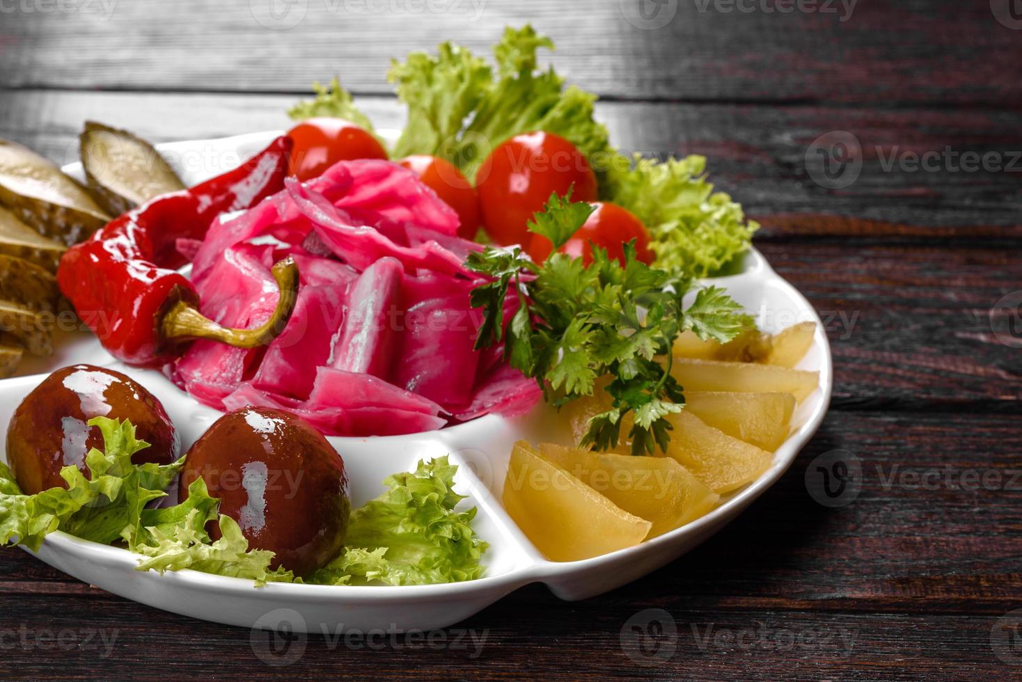 délicieux cornichons épicés coupés sur une assiette de service photo