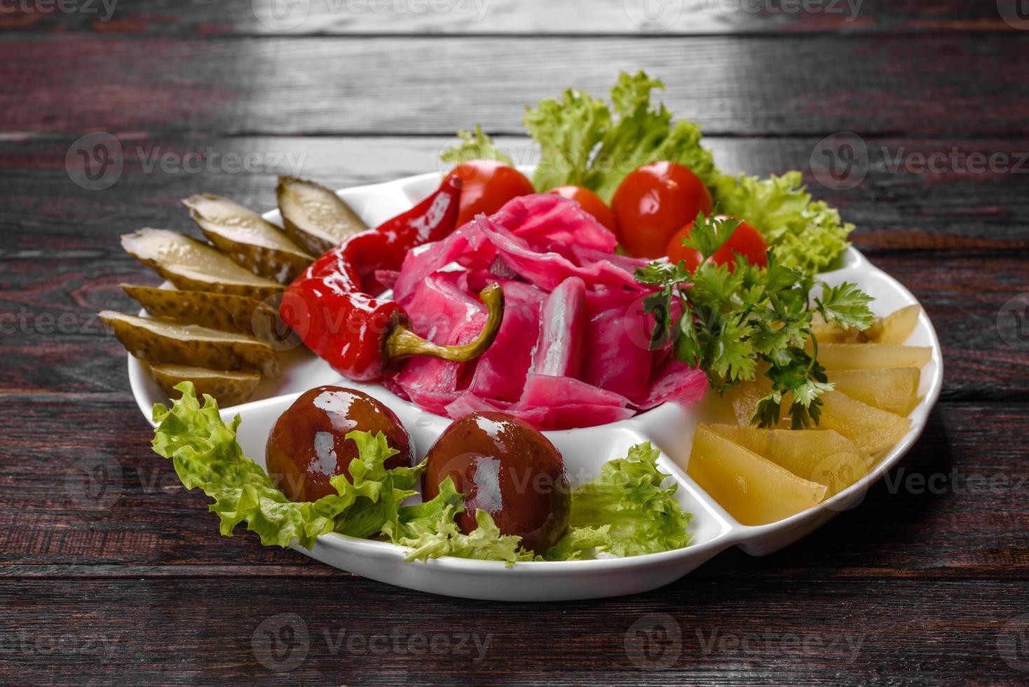 délicieux cornichons épicés coupés sur une assiette de service photo