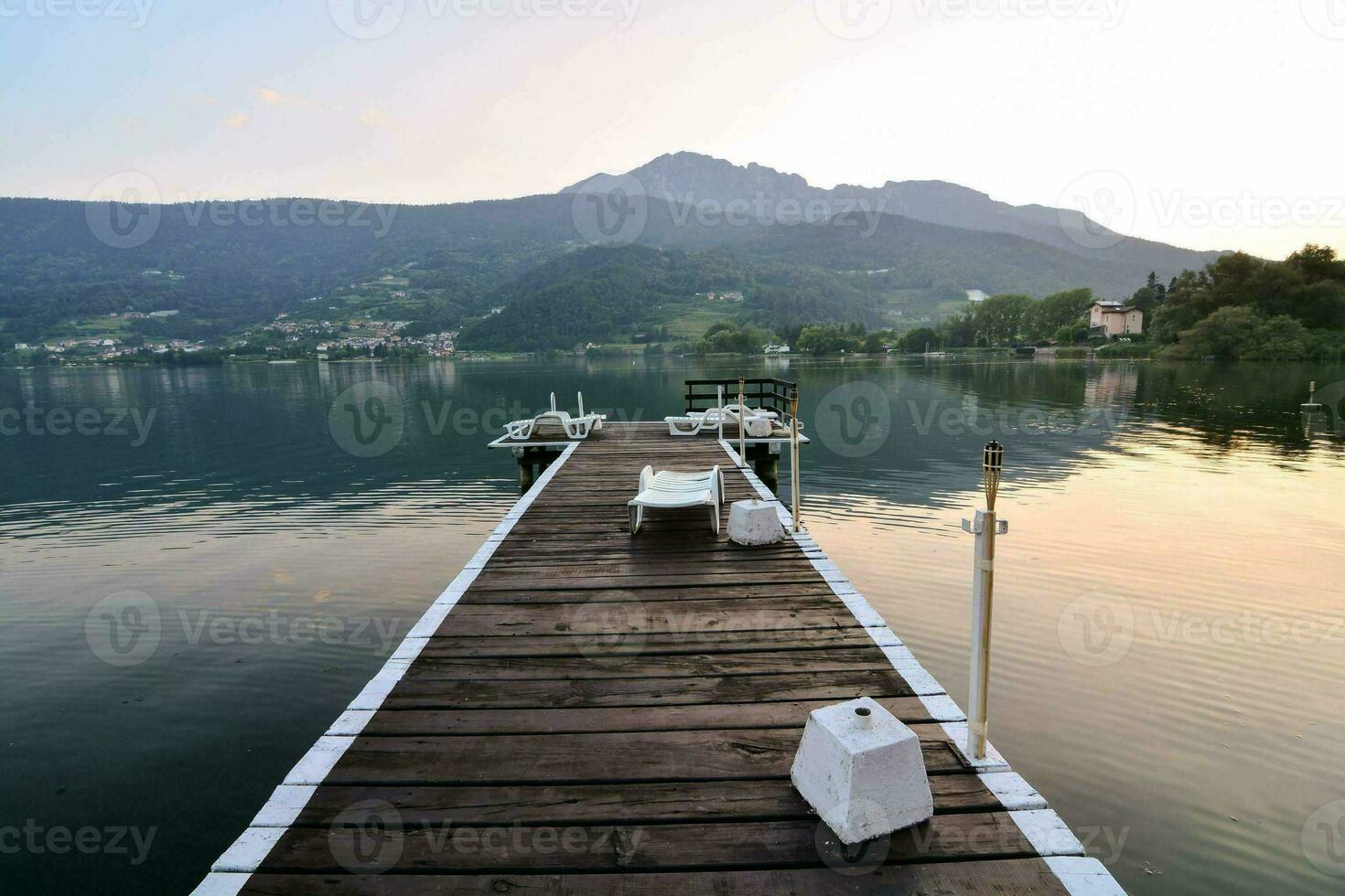 une en bois Dock étend dans le l'eau à le coucher du soleil photo