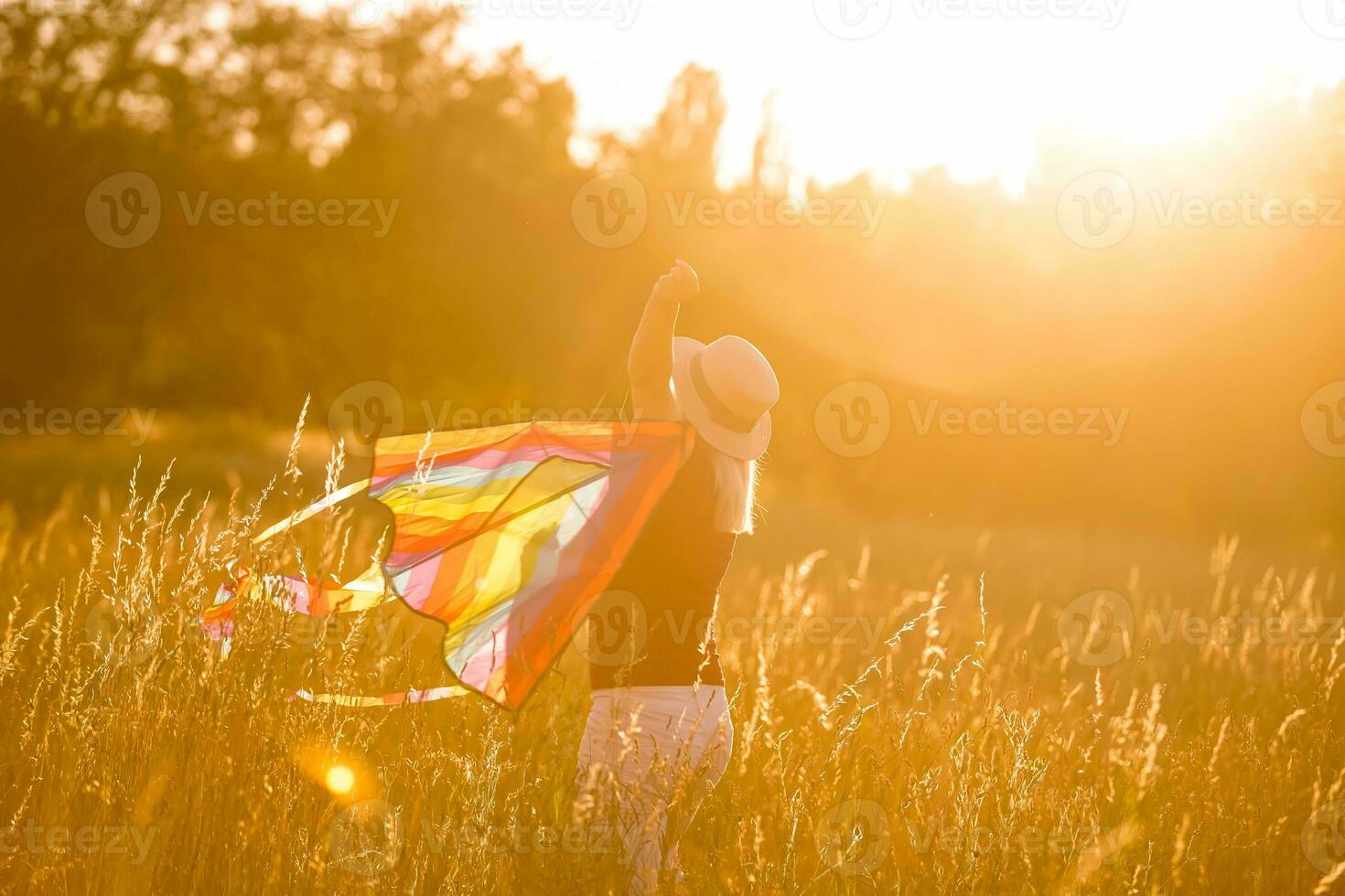 portrait de une Jeune et insouciant femme lancement cerf-volant sur le champ vert. concept de actif mode de vie dans la nature photo