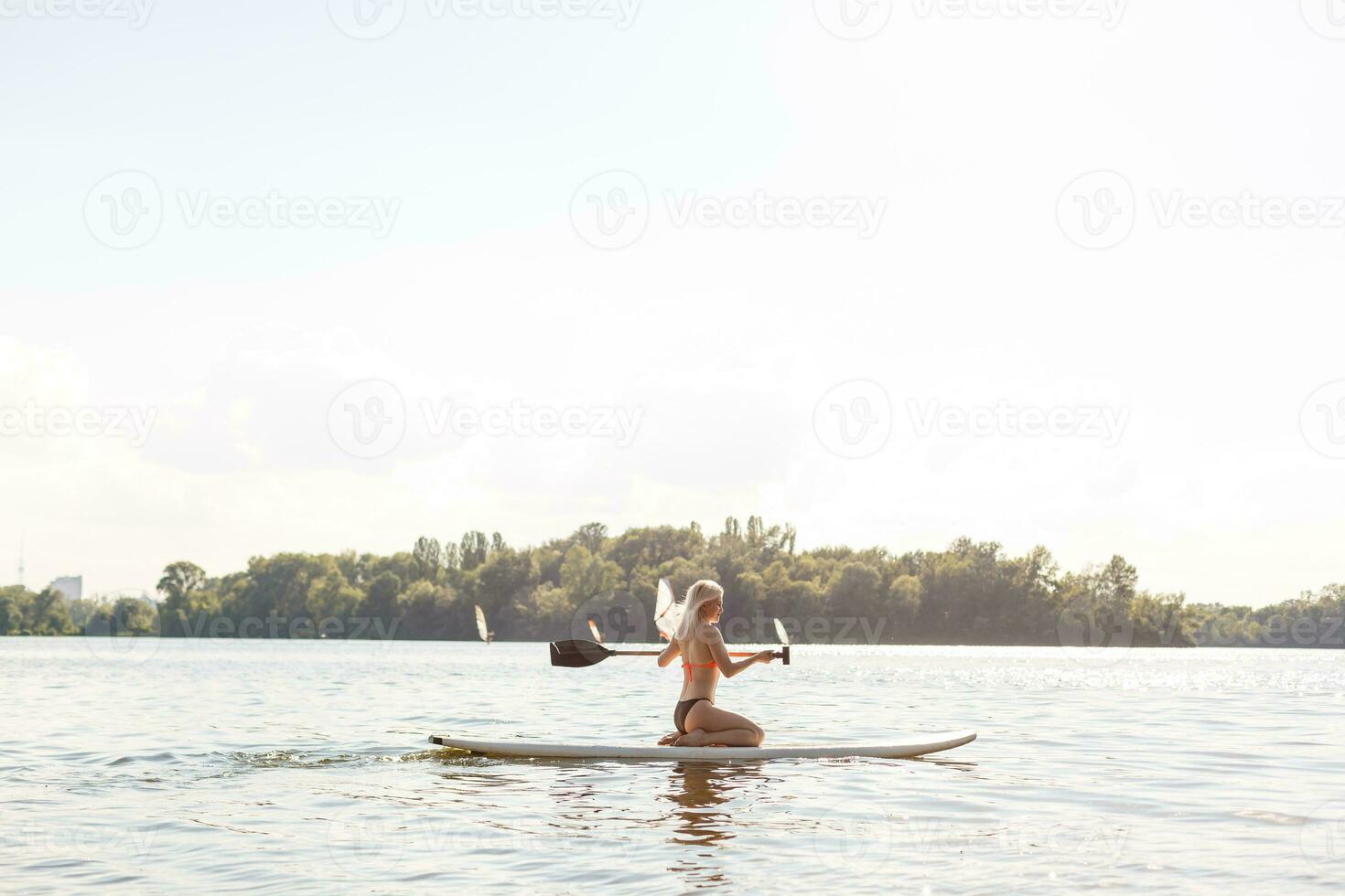 action coup de Jeune femme sur pagayer planche photo