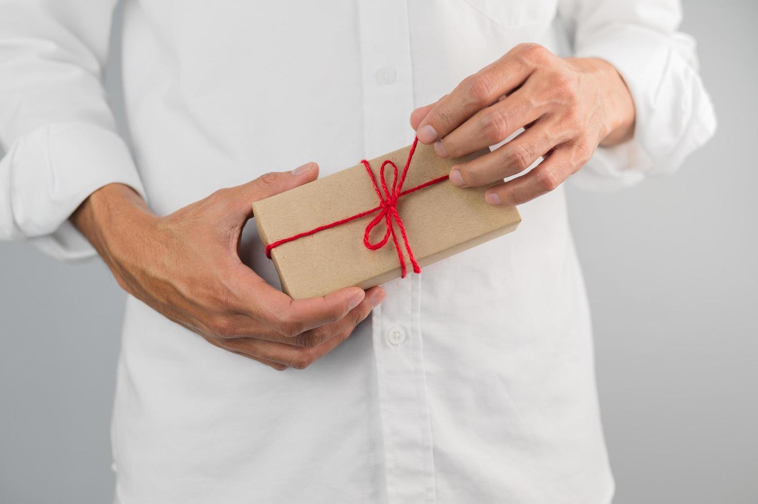 main tenant une boîte-cadeau, une boîte-cadeau de nouvel an, une boîte-cadeau de Noël, un espace de copie. noël, nouvelle année, concept d'anniversaire. photo