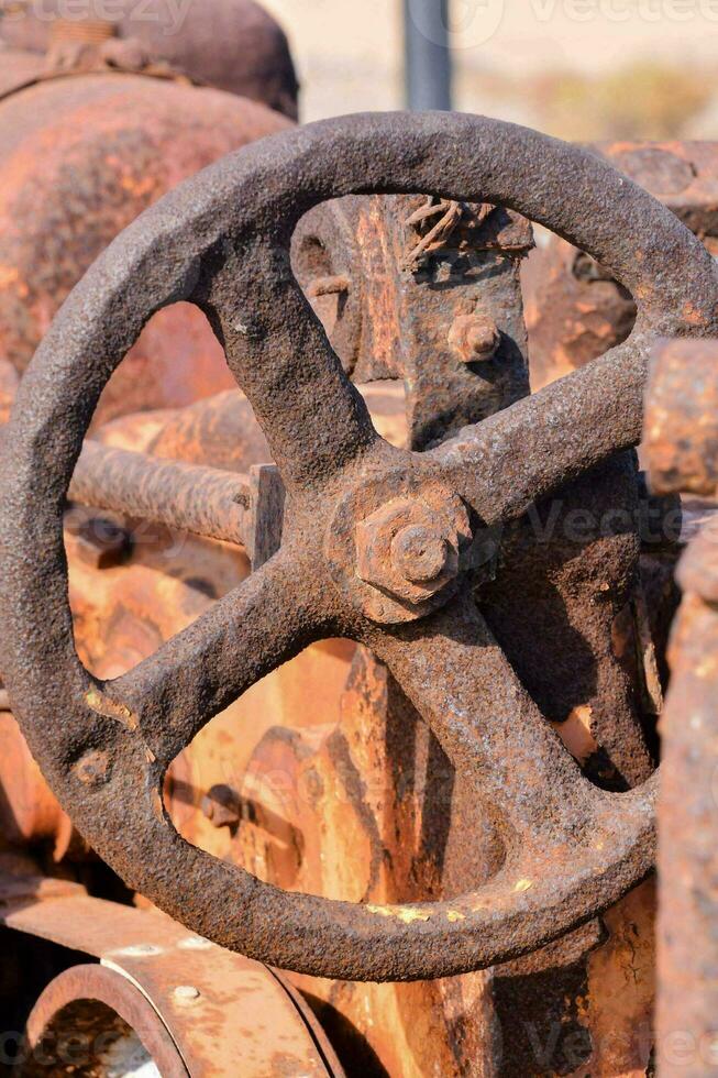 un vieux rouillé tracteur roue avec une rouillé métal équipement photo