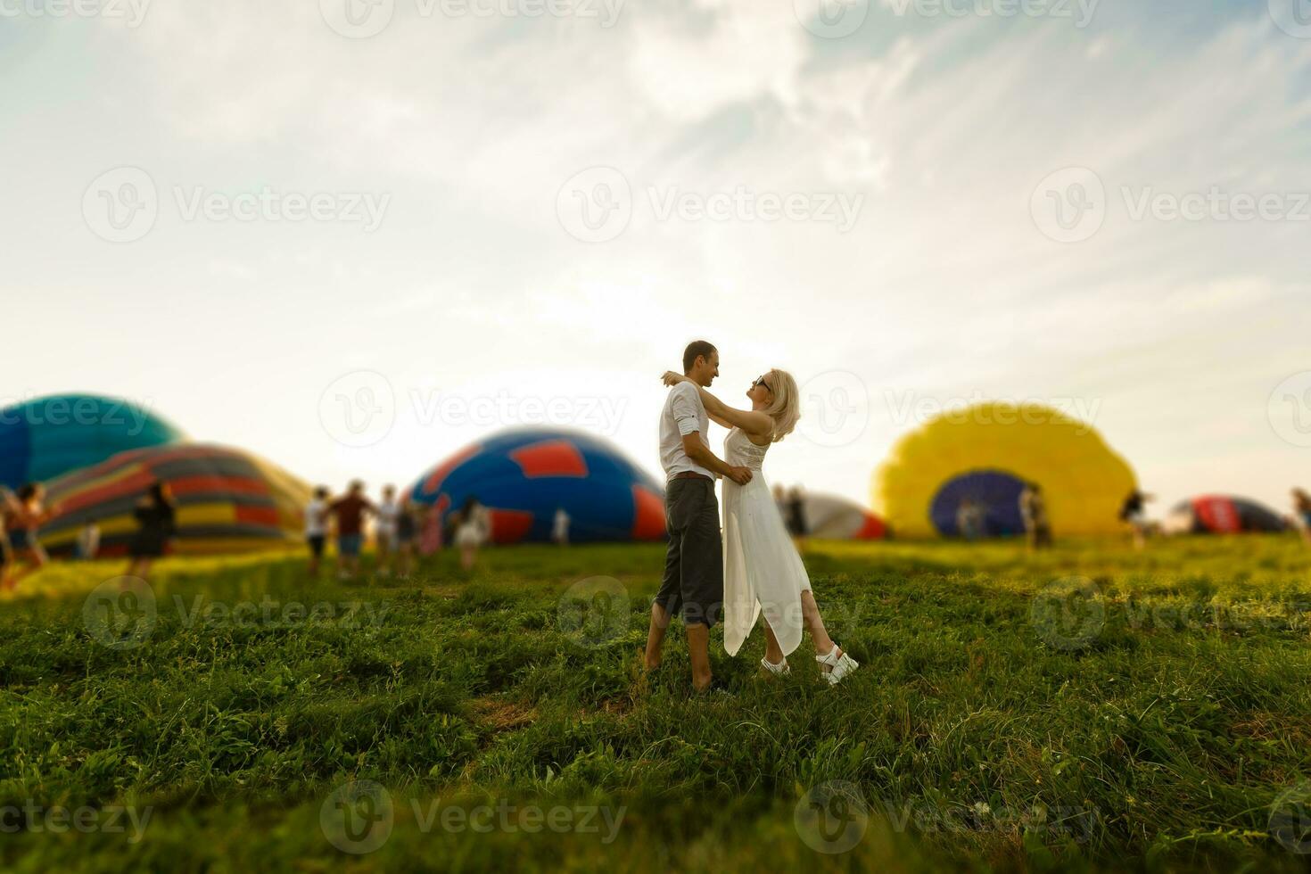 magnifique romantique couple étreindre à prairie. chaud air ballon sur une Contexte photo