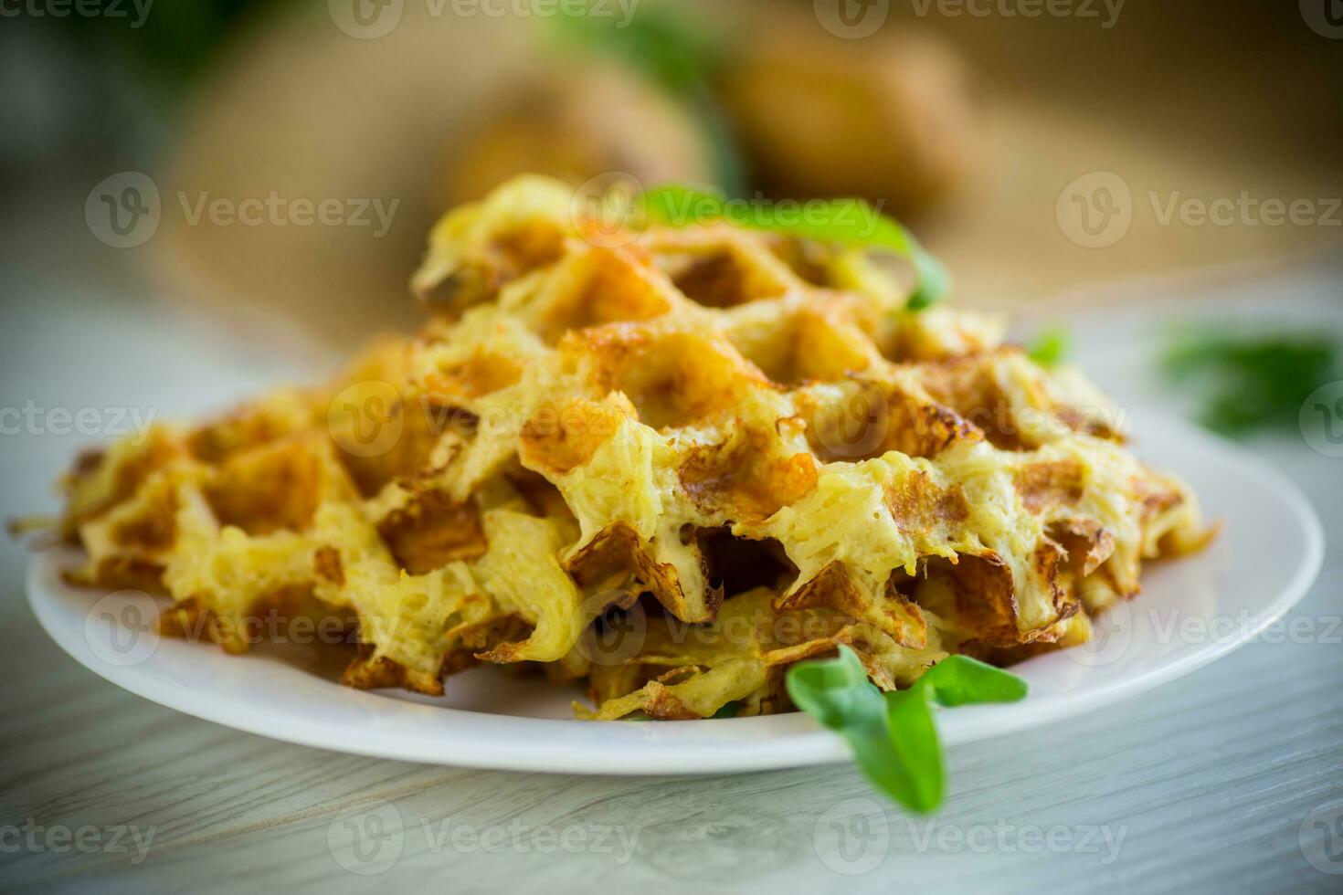 frit Patate gaufres avec fromage dans une assiette sur en bois tableau. photo