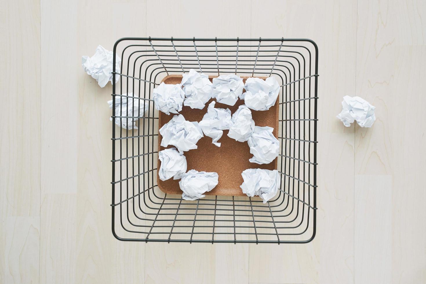 corbeille et papier froissé. déchets de papier débordant dans les ordures de bureau photo