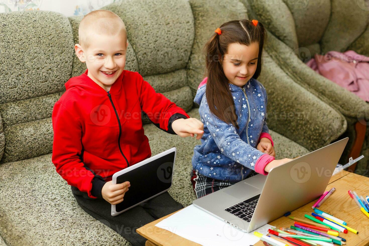 distance apprentissage en ligne éducation. école garçon et fille en train d'étudier à Accueil avec portable carnet et Faire devoirs. séance à une table photo