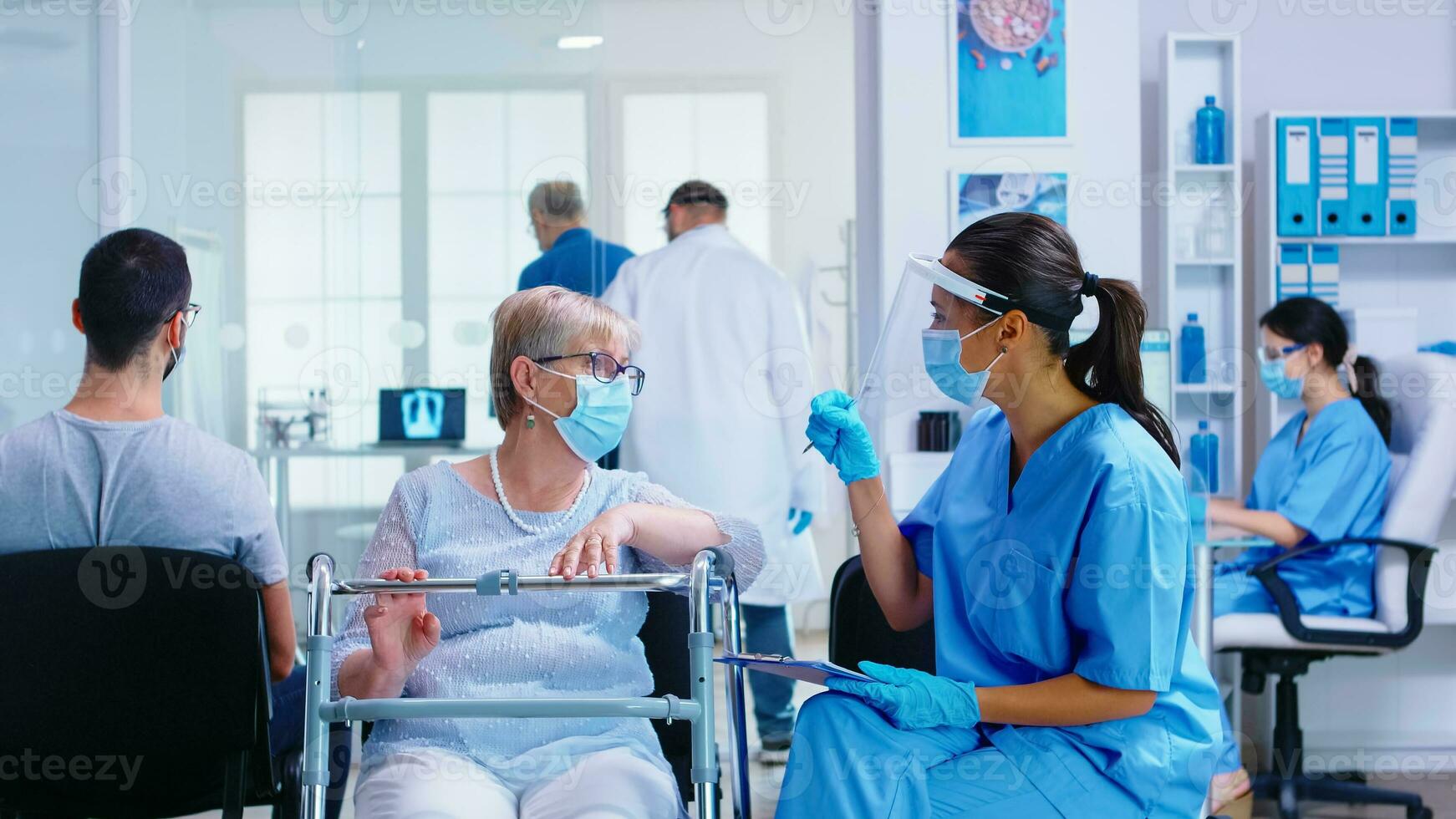 infirmière avec visière contre coronavirus dans hôpital attendre zone expliquant diagnostic à désactivée Sénior femme avec en marchant Cadre. santé se soucier système pendant global pandémie. photo