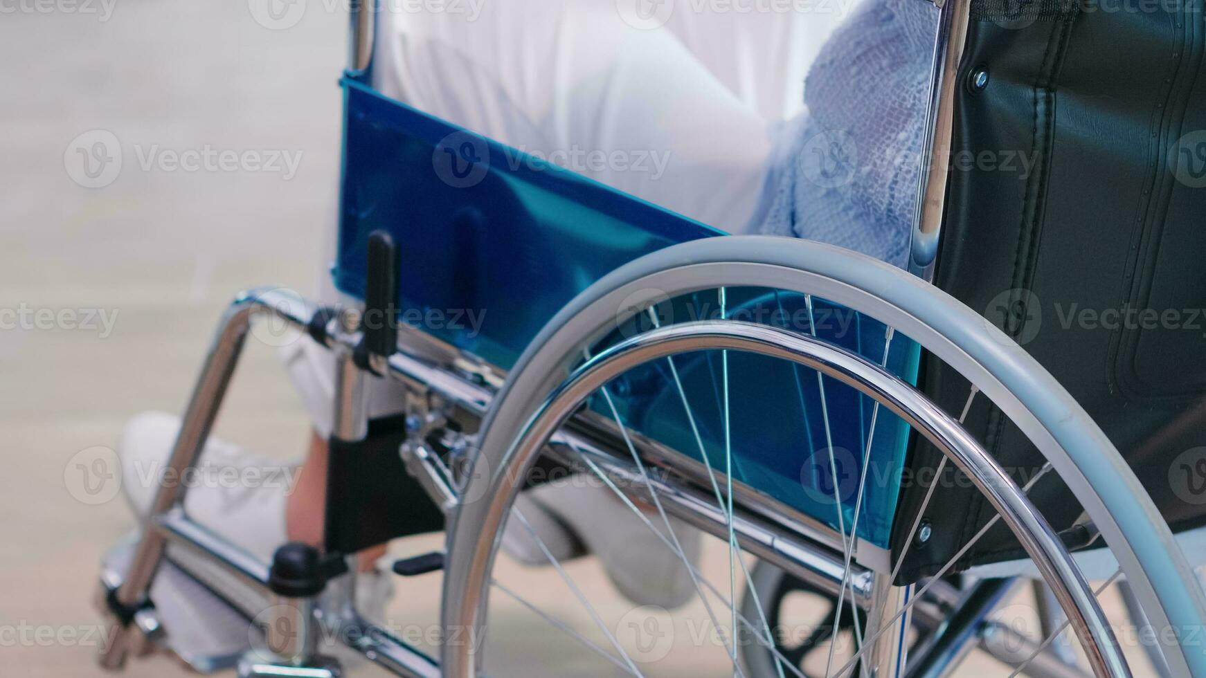 désactivée vieux femme en portant mains sur chaise roue dans hôpital couloir. désactivée invalidité handicapé déficience maladie traitement et patient paralysie photo