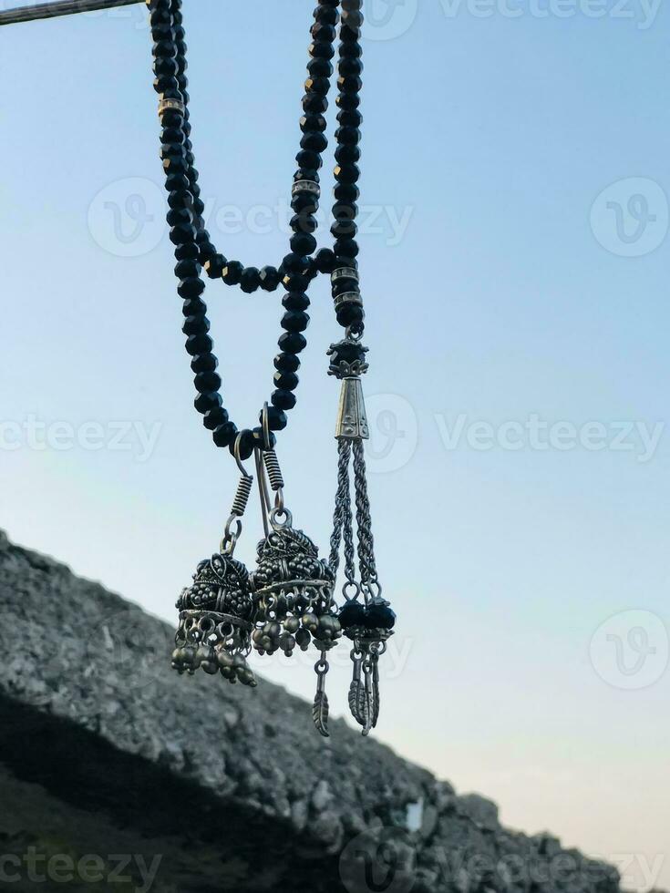 une Collier avec noir perles pendaison de une corde photo