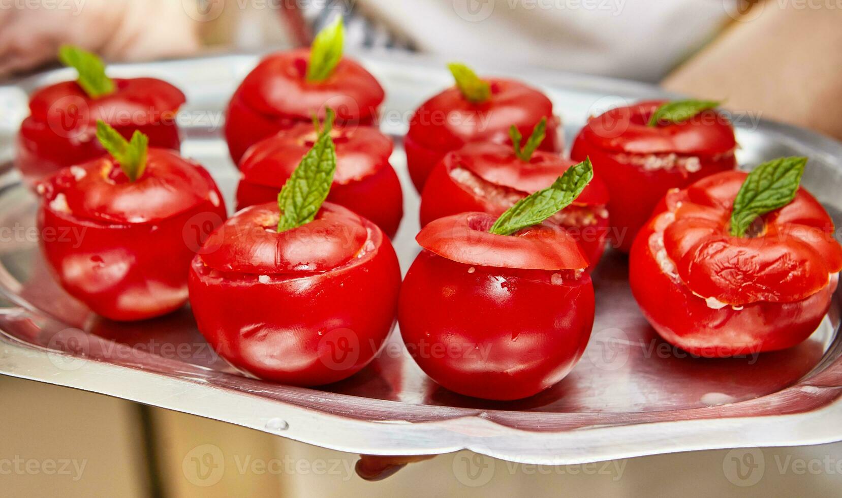 rustique cuisine scène avec farci tomates et menthe feuilles sur métal plateau photo