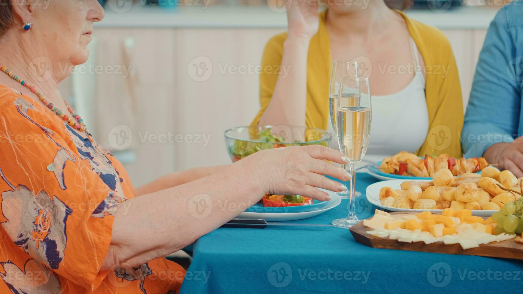 Sénior femme en portant une verre de vin, Jeune content couple dépenses bien temps dans famille. multi génération, quatre personnes, deux content des couples parlant et en mangeant pendant une gourmet dîner, profiter temps à maison. photo