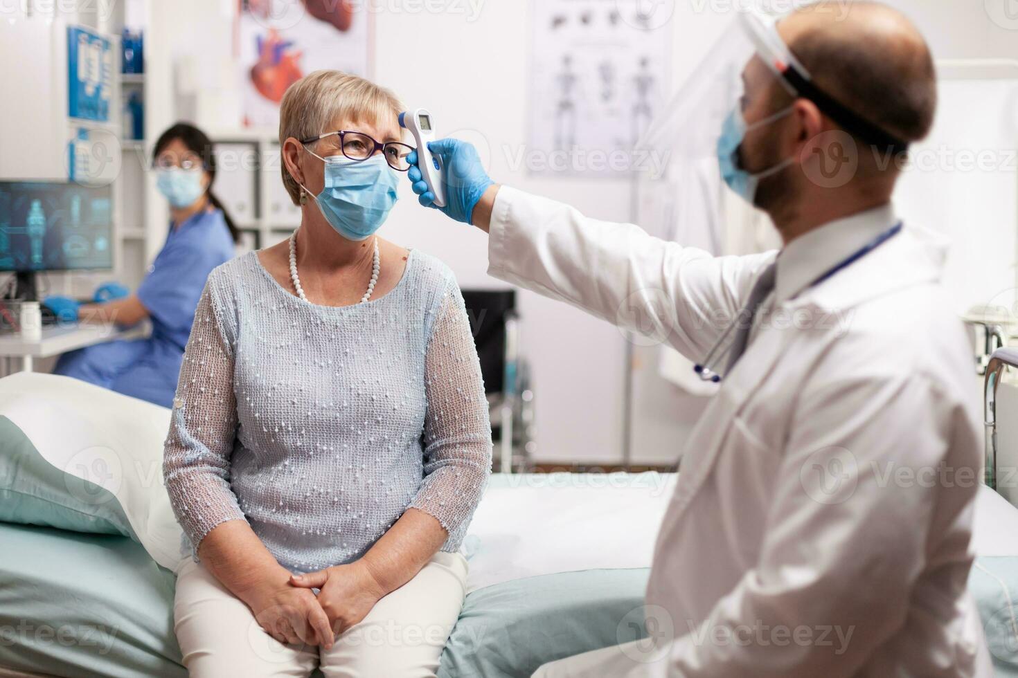 infirmière vérifiant la température du patient dans l'oreille avec