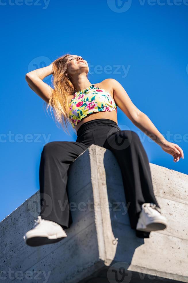 drôle de jeune fille assise sur un mur urbain photo