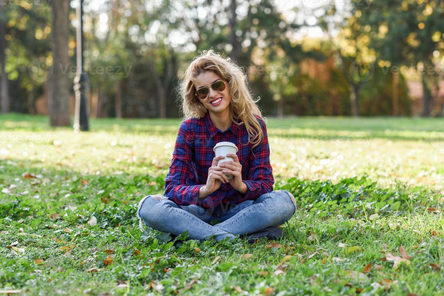 belle femme buvant du café dans le parc photo