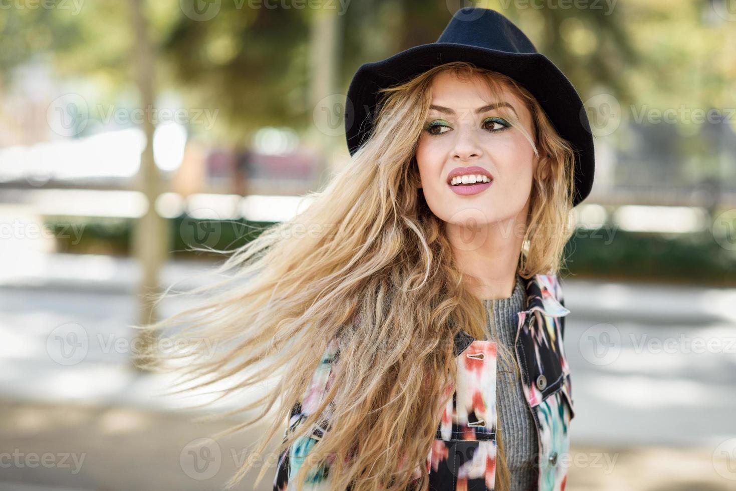 jeune femme aux cheveux volants portant veste et ha photo