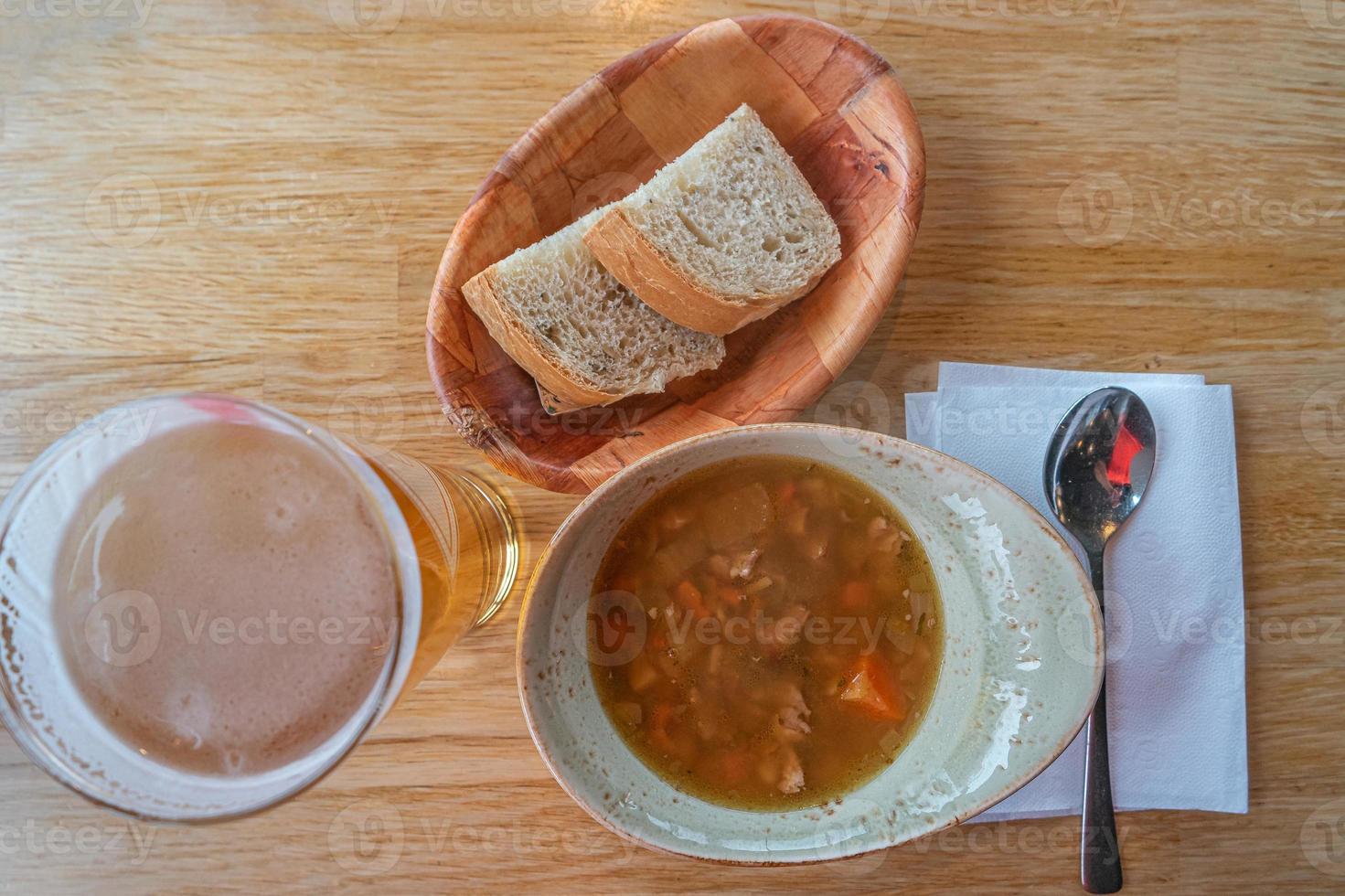 soupe de viande d'agneau islandaise et scandinave traditionnelle avec du pain blanc dans une assiette en bois et un verre de bière, islande, gros plan, détails. photo