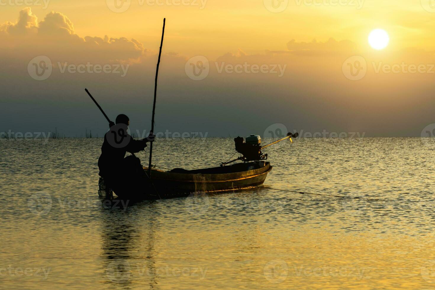 silhouette pêcheur et le coucher du soleil ciel sur le lac. photo