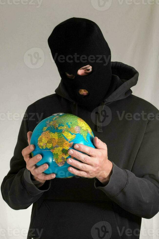 une homme dans une noir sweat à capuche en portant une globe photo