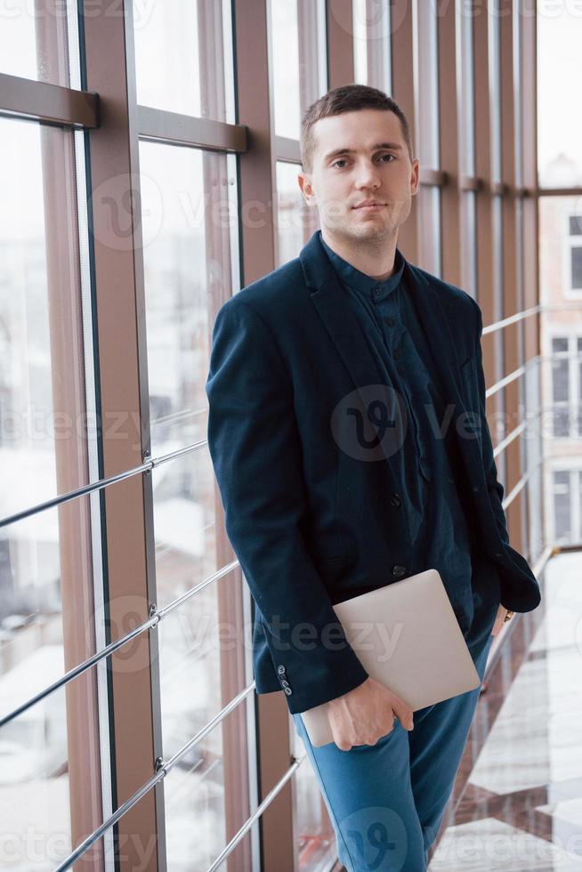 Heureux homme d'affaires jeune travaille dans un bureau moderne sur ordinateur photo