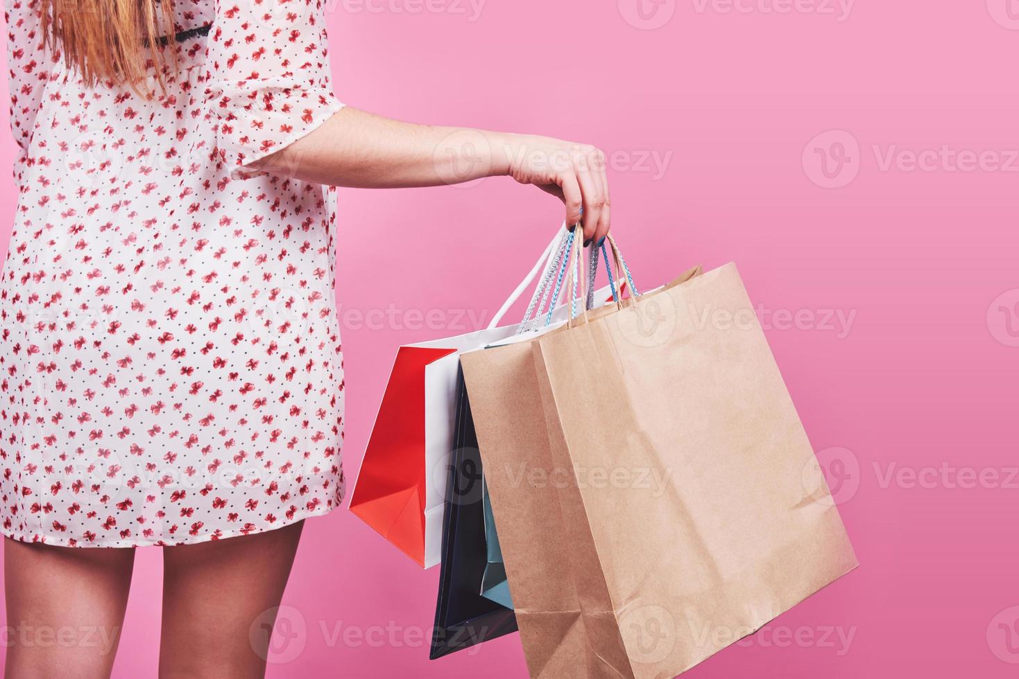 gros plan, de, femme, main, tenue, coloré, sacs provisions, sur, fond rose photo