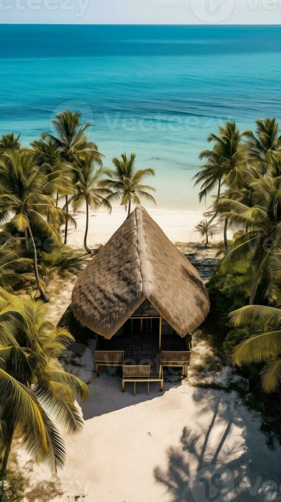 ai généré aérien vue de un isolé chaume cabane sur une tropical plage avec fond photo