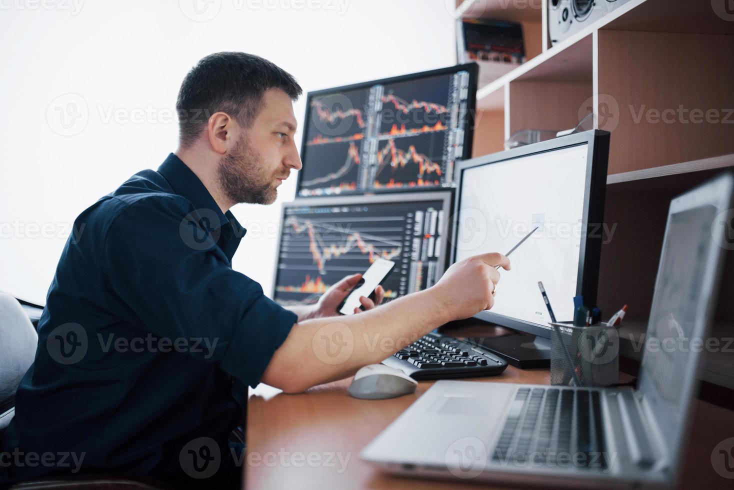 agent de change en chemise travaille dans une salle de surveillance avec écrans d'affichage. concept graphique de finance forex trading bourse. hommes d'affaires négociant des actions en ligne photo