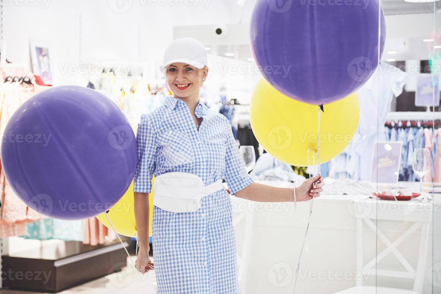 concept de vente, de mode, de consommation et de personnes - jeune femme heureuse avec des sacs à provisions choisissant des vêtements dans un centre commercial ou un magasin de vêtements photo