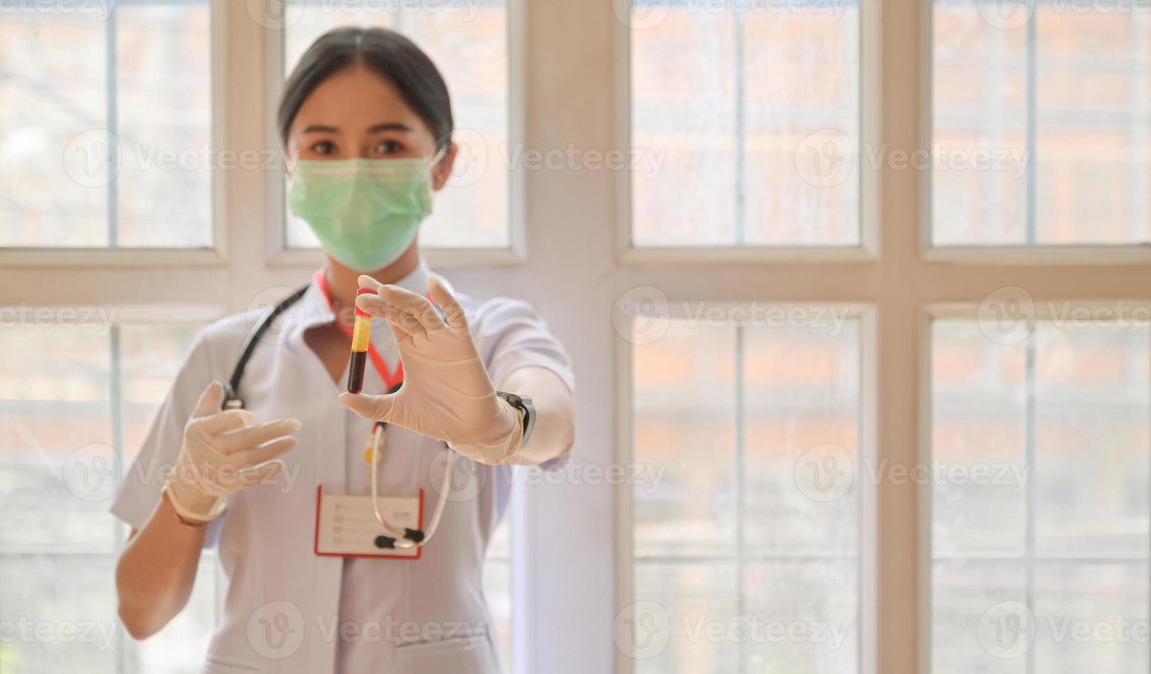 infirmière portant des gants avec un tube à essai sanguin avant, concepts examinant l'infection par le virus covid-19. photo