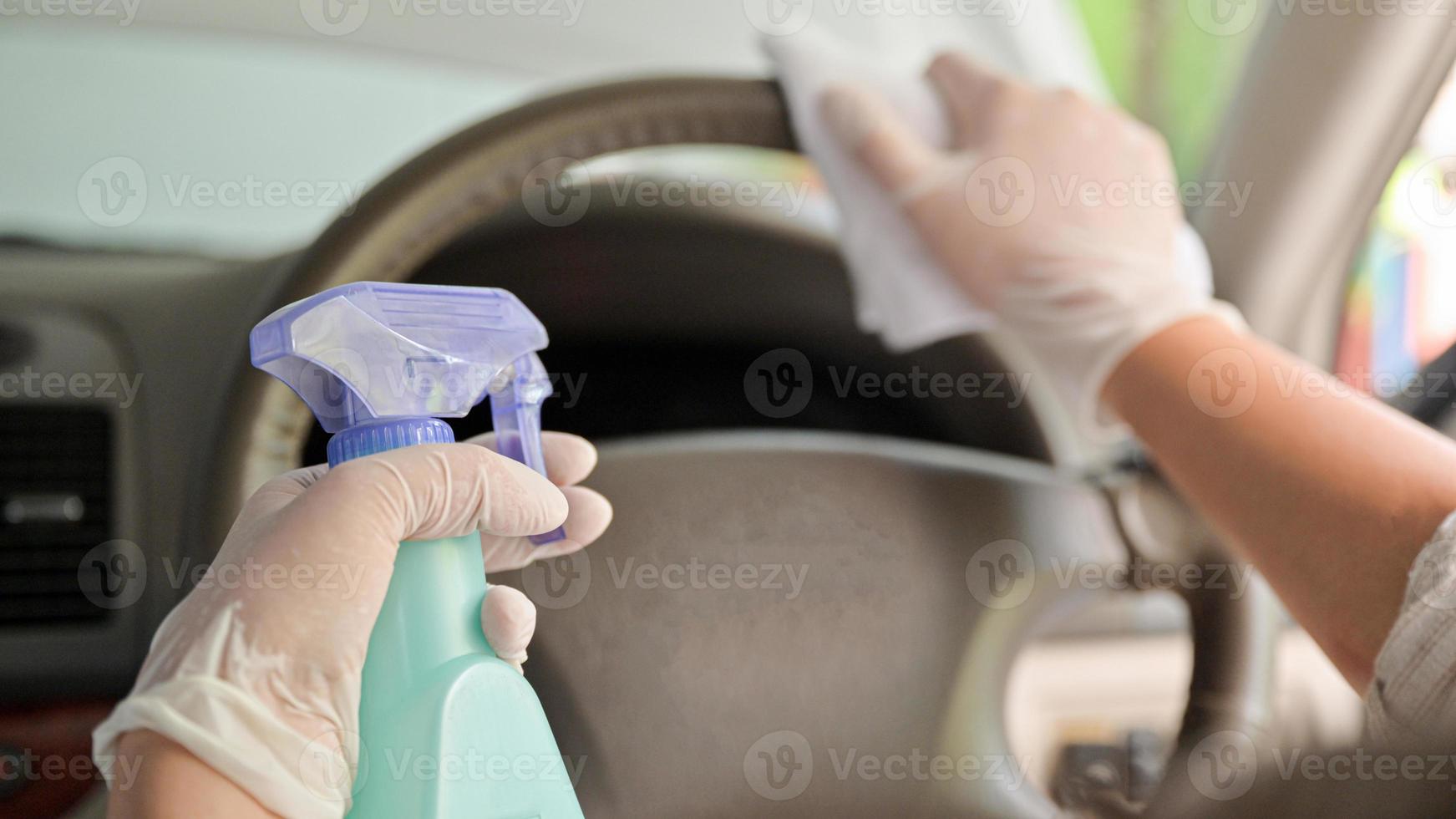 photo recadrée de spray pour nettoyer et désinfecter le volant et l'intérieur de la voiture.