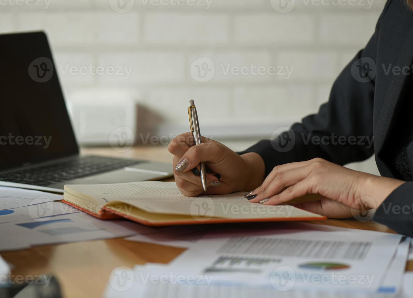 les femmes d'affaires prennent des notes de travail sur le bureau du bureau. photo