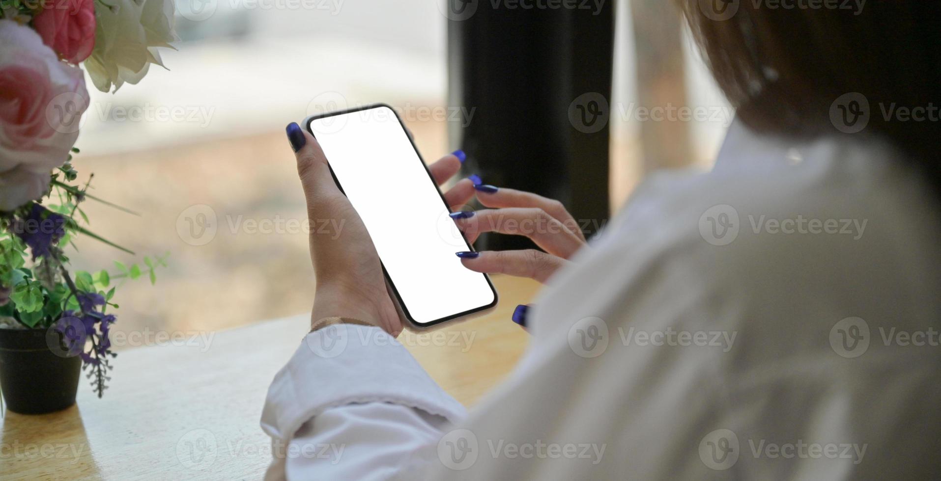 main d'une jeune femme utilisant un smartphone pour rechercher des informations sur internet. photo
