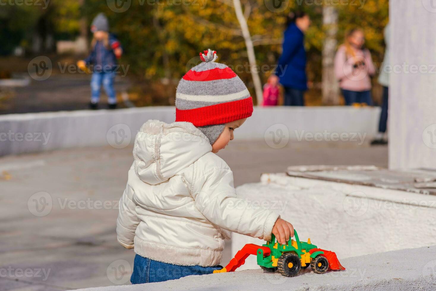 peu enfant en jouant avec un excavatrice sur le rue photo