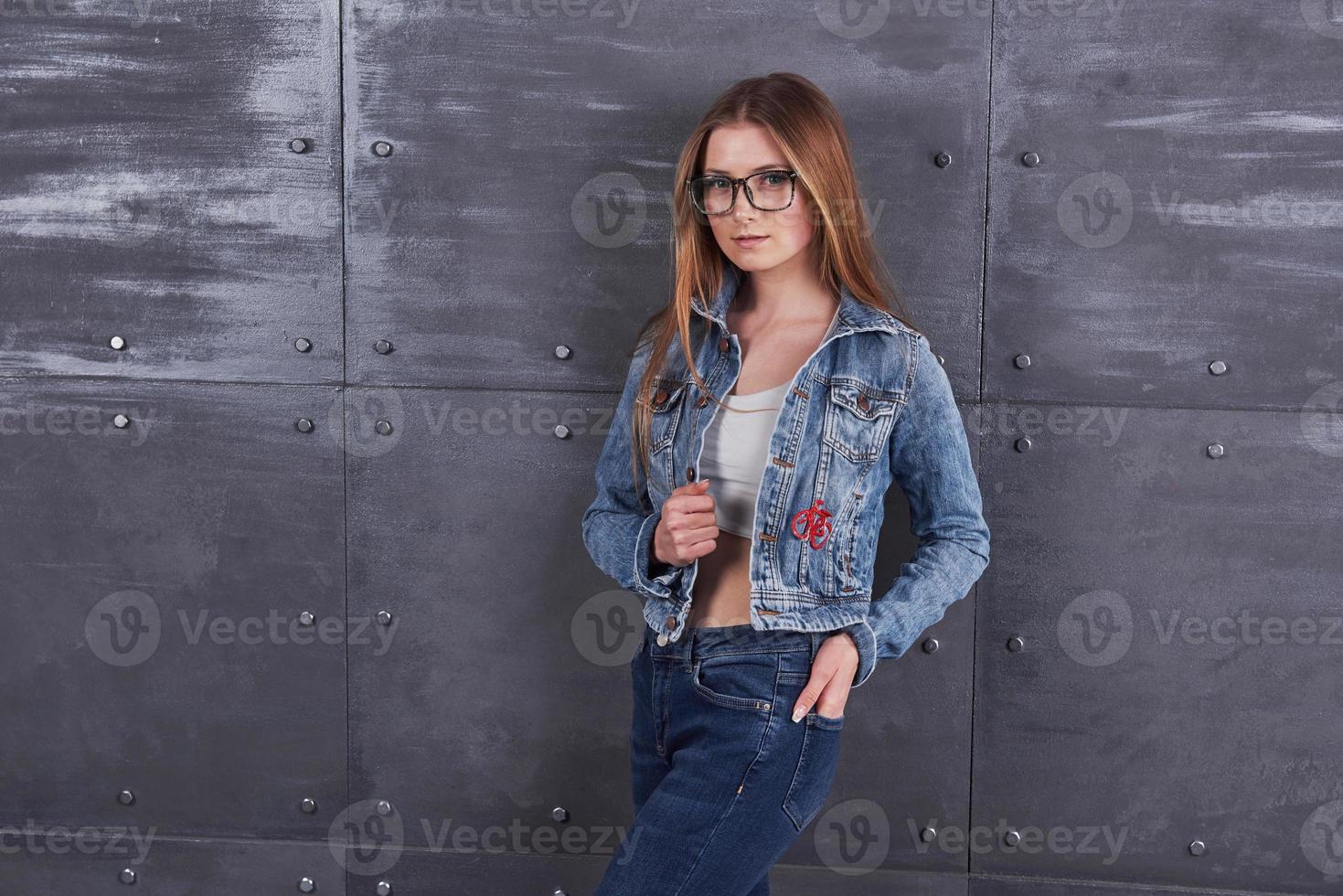 mode, vêtements, concept de personnes. jolie jeune femme sexy avec une veste en jean. fille pose en studio photo