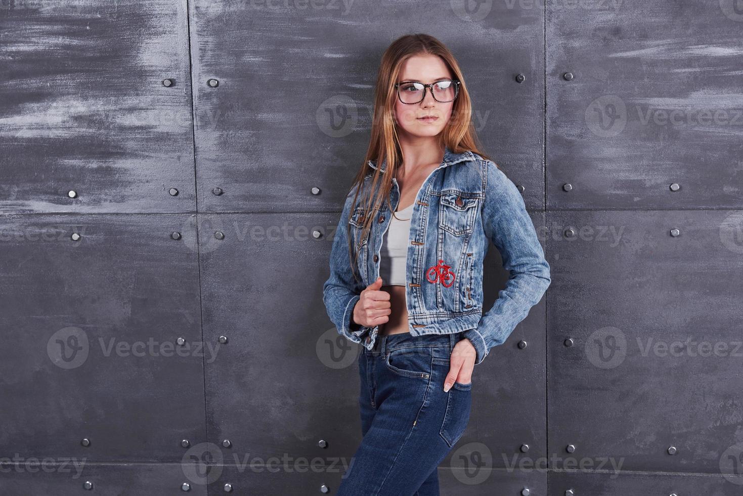 mode, vêtements, concept de personnes. jolie jeune femme sexy avec une veste en jean. fille pose en studio photo