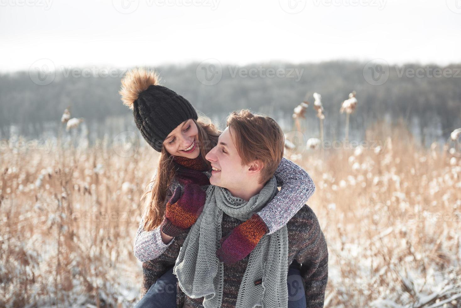 heureux couple ludique ensemble pendant les vacances d'hiver à l'extérieur dans le parc à neige photo