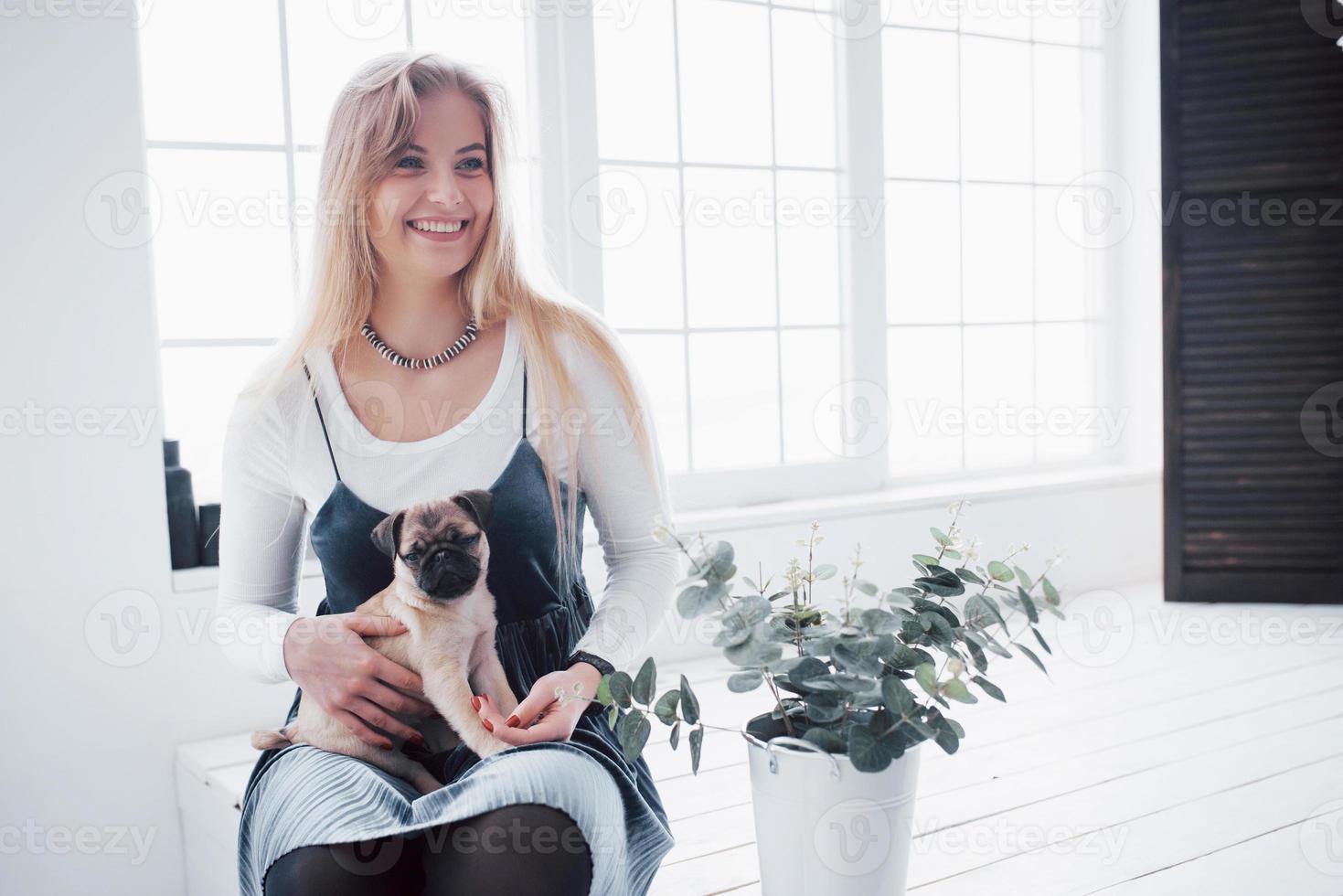 jolie jeune fille avec un chien carlin mignon sur les mains photo