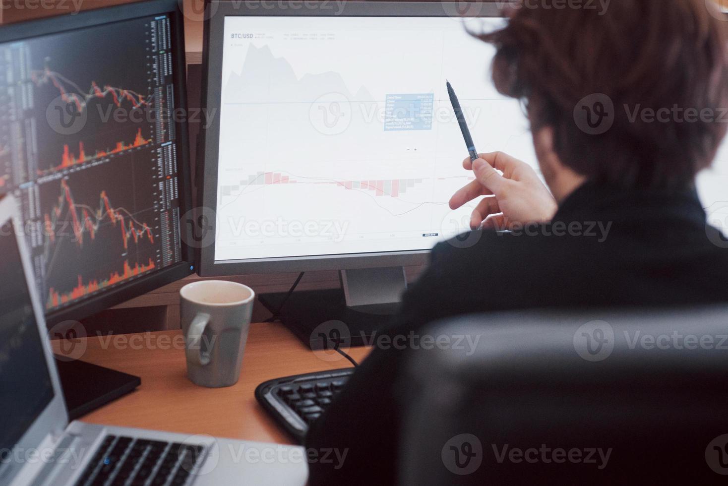 développer de nouvelles approches. vue arrière du jeune homme en tenue décontractée travaillant assis au bureau dans un bureau créatif photo